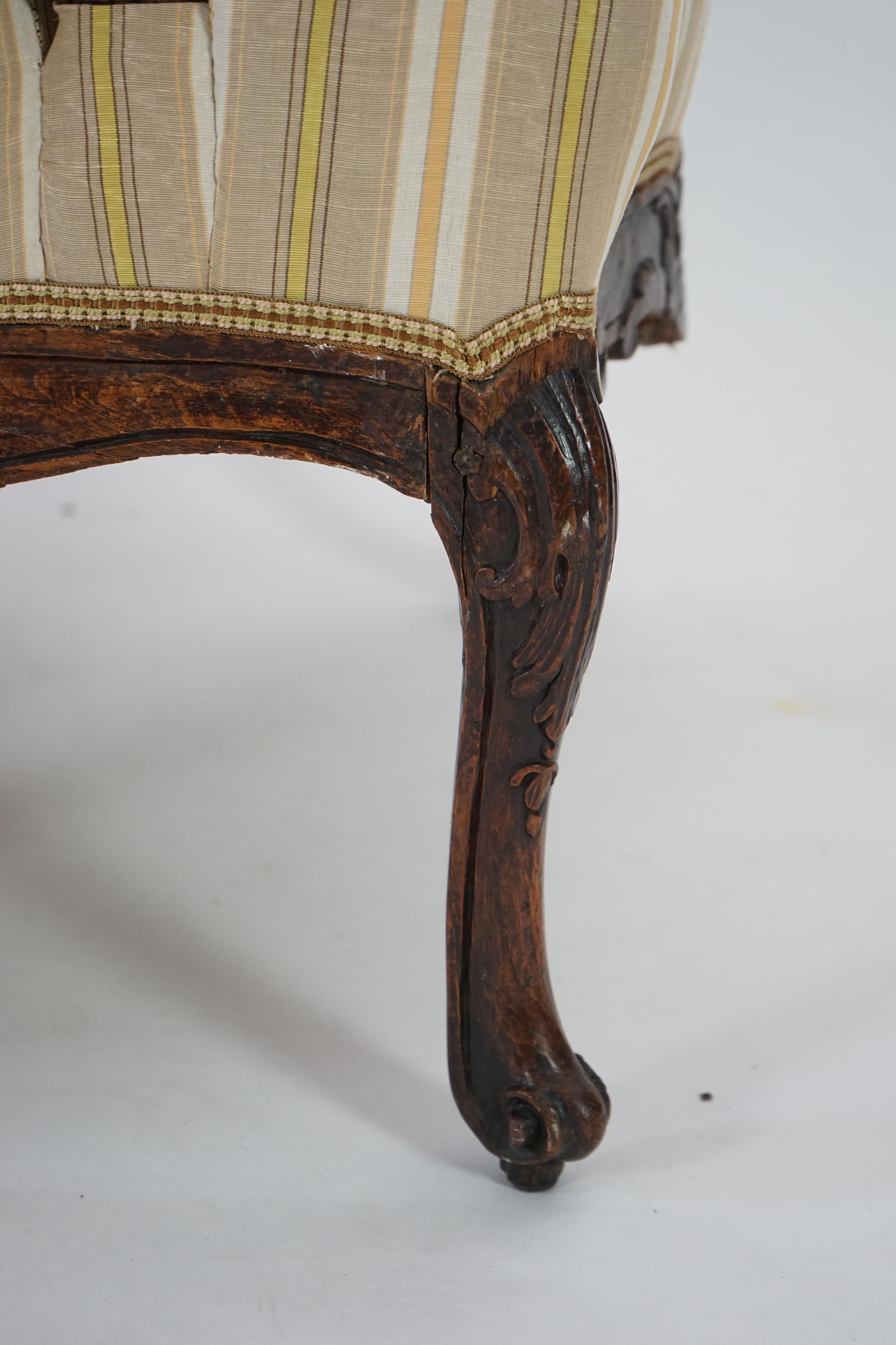 A pair of Louis XVI walnut fauteuils with upholstered backs and seats and foliate carved arms and underframes, on cabriole legs, width 67cm, depth 76cm, height 104cm. Condition - fair